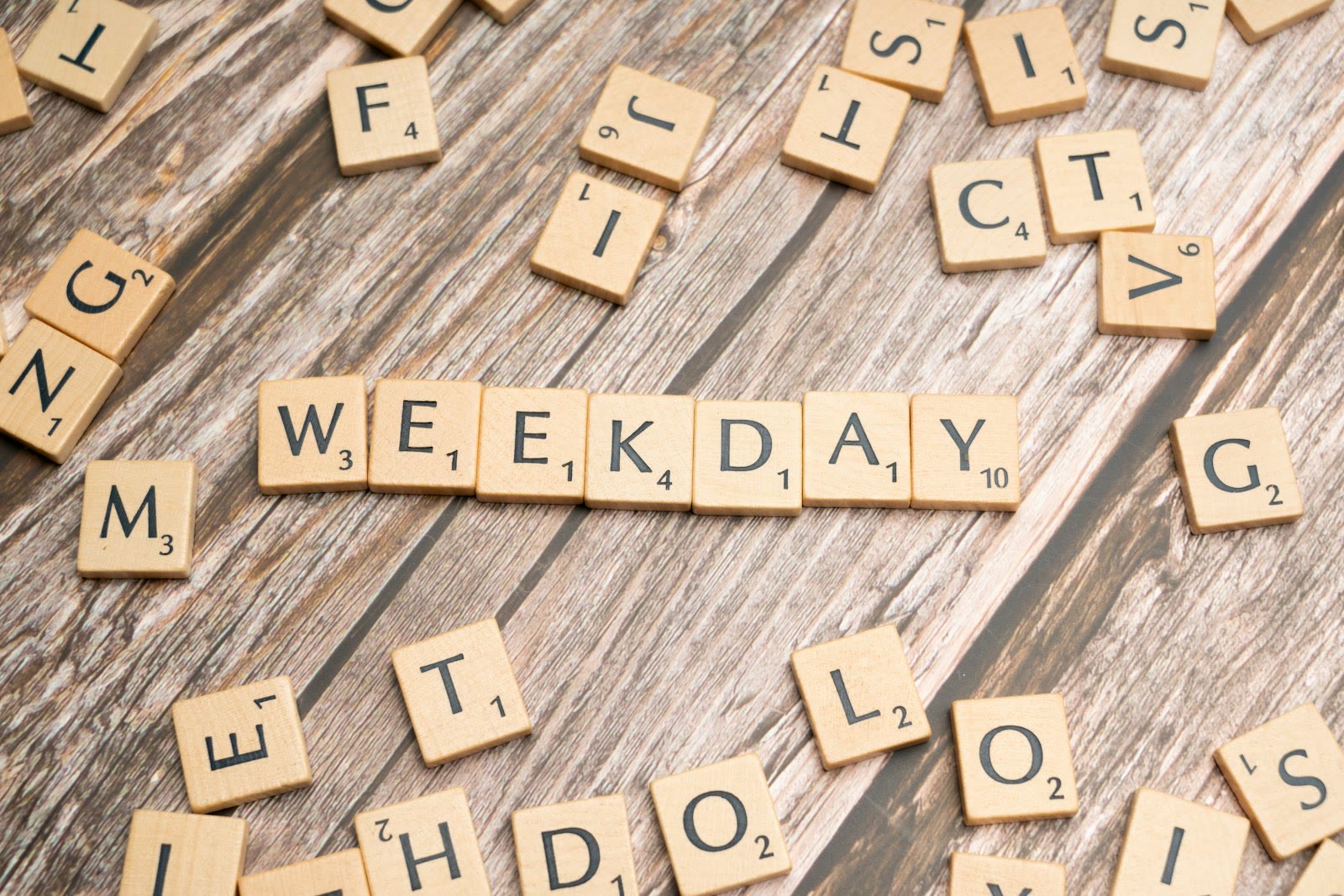 scrabble tiles spelling the word wednesday on a wooden surface