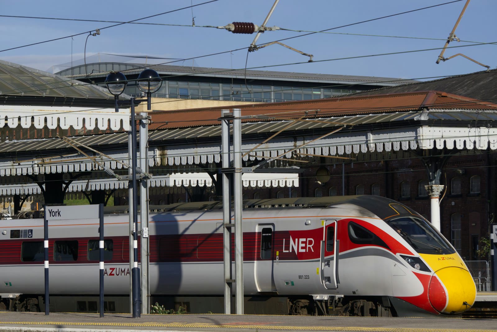 Modern train at a station with overhead wires