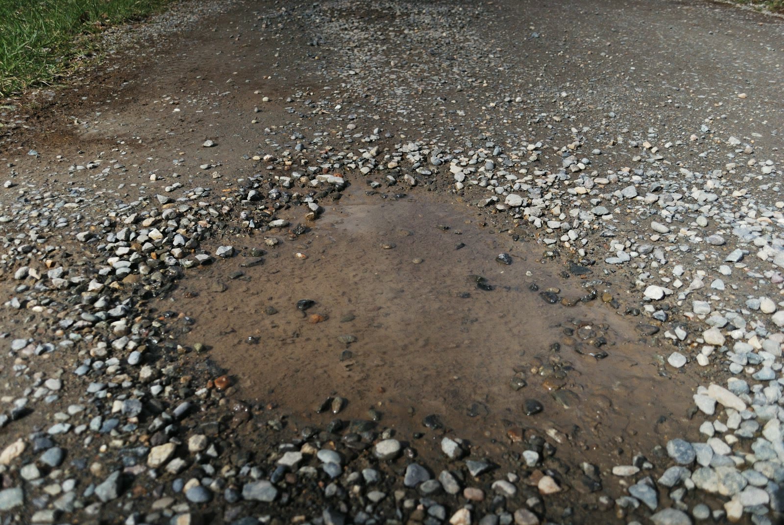 a puddle of water in the middle of a road