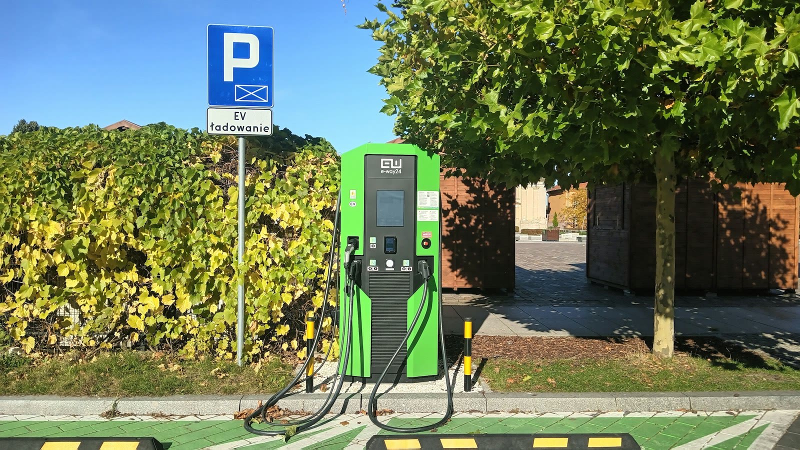 A green gas pump sitting on the side of a road
